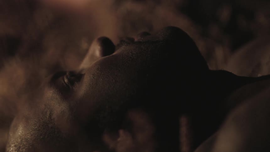 A man is blinking as he lays in the grass