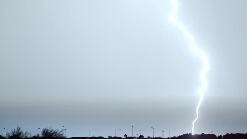 Lightning bolts crack the darkness of the night sky and light up the area with bright flashes