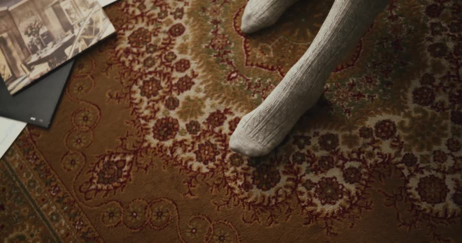A person in socks tapping their toe while sitting on a rug