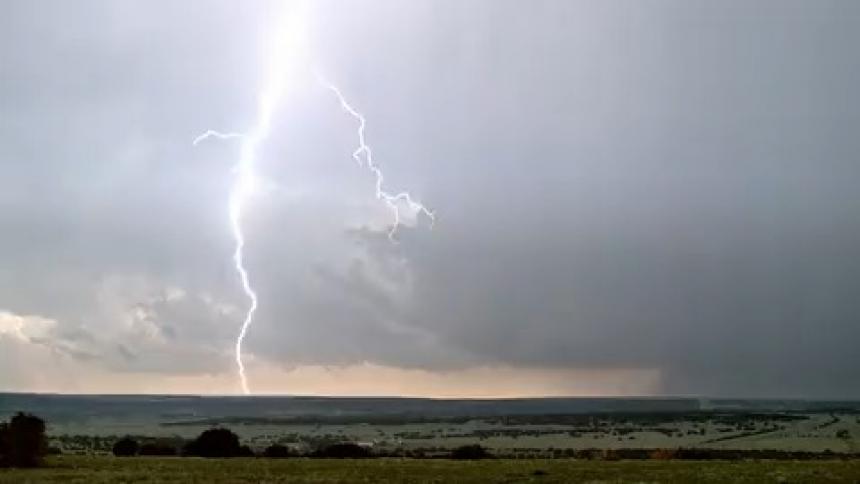 Lightning strikes over a farm and field