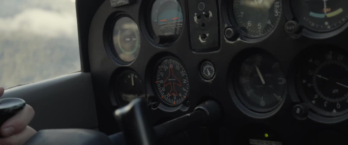 A person is flying an airplane high above a forest