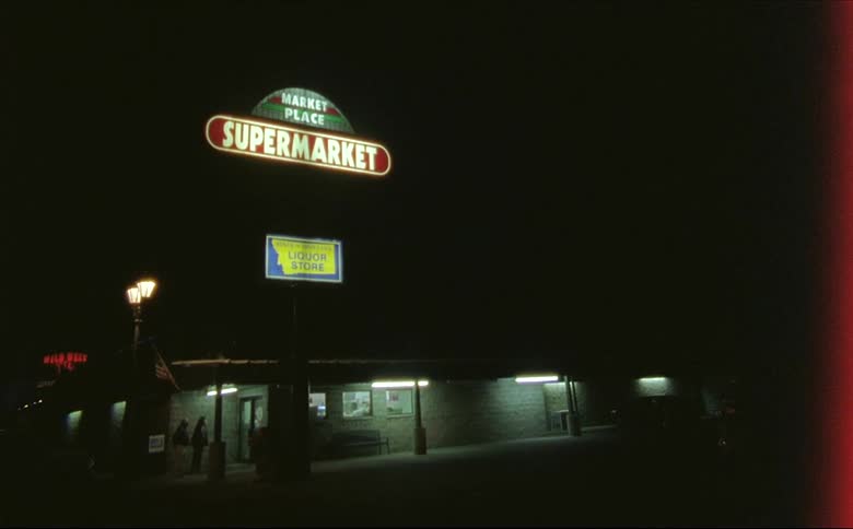 A small supermarket lit up at night in Montana shot on 16mm film