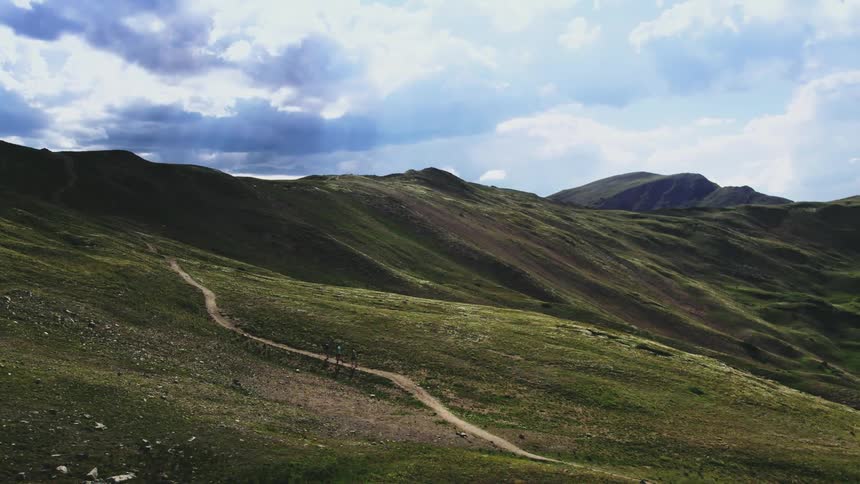 A view of three people hiking up a mountain