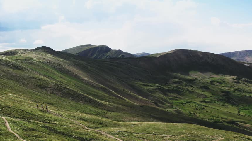 An aerial view of hikers climbing a hillside