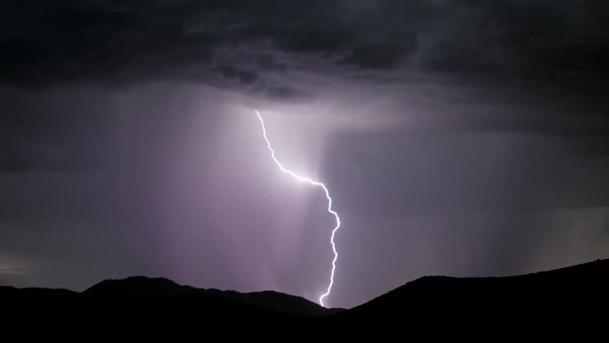Lightning flashing in a dark night sky during a rainstorm
