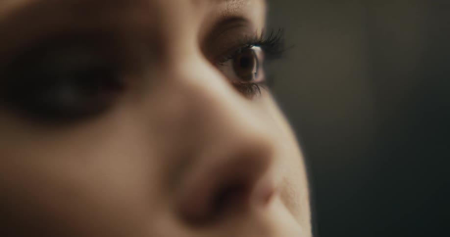 A woman looks down and up while blinking rapidly