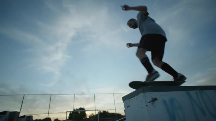 A man going off a jump on a skateboard at sunset