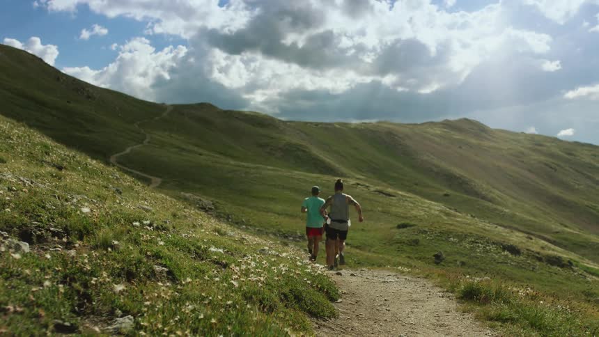Men jog on track in the green mountains