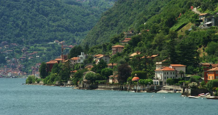 Coastal town next to sea and high green mountain