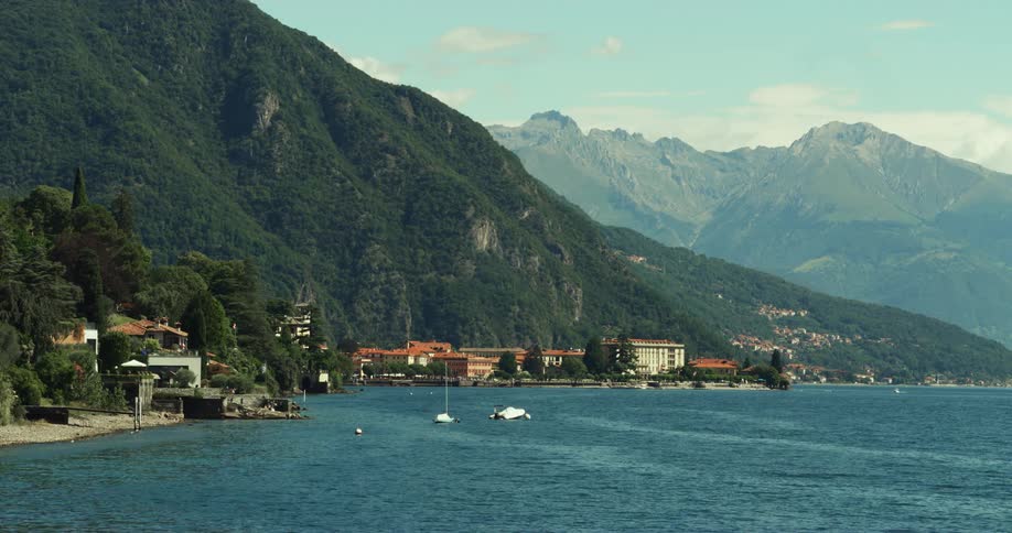 Coastal town in front of high green mountain