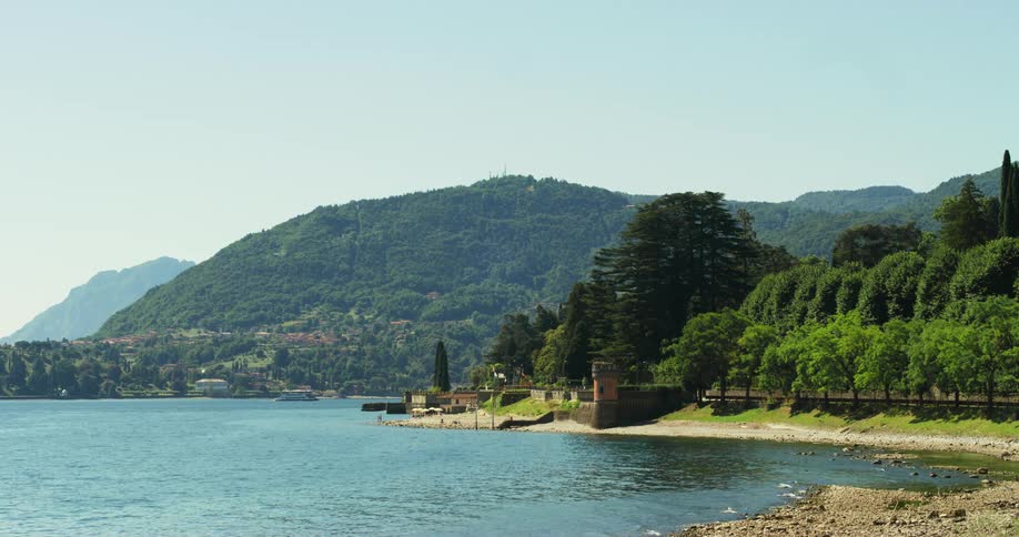 A car drives by on the shore of a lake in the mountains