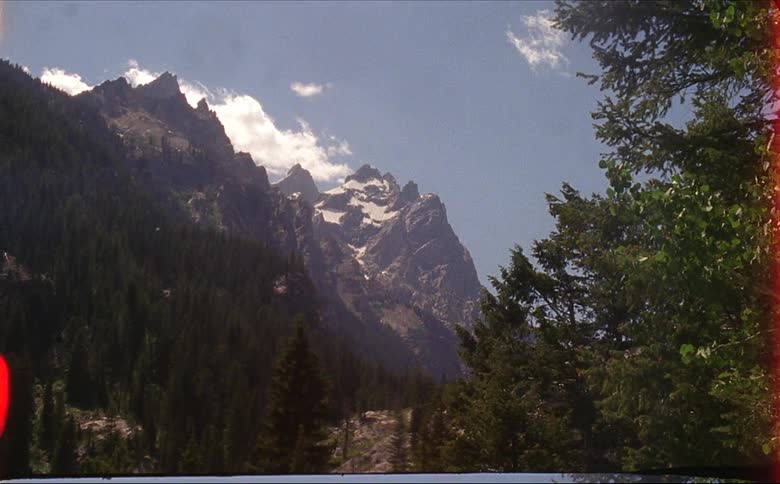 Grand Teton Peak towering above the valley of trees in Grand Teton National Park on 16mm film