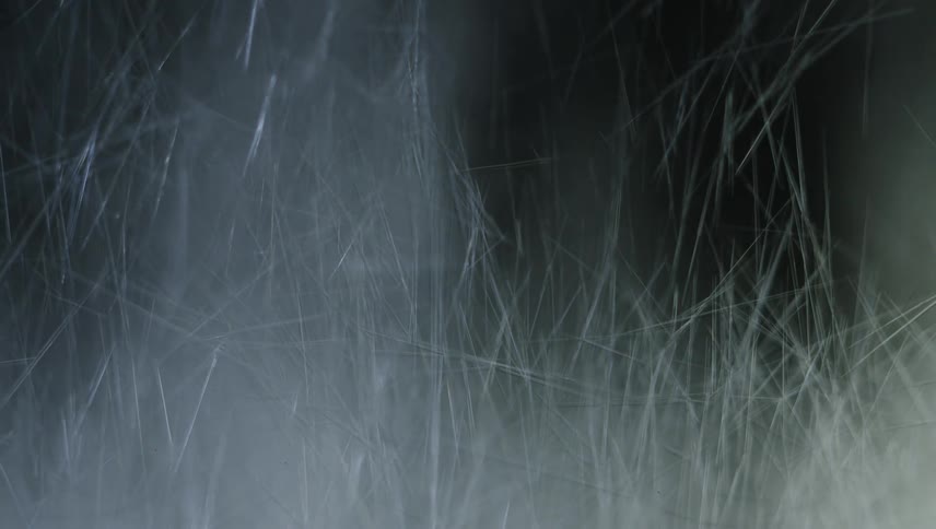 Shards and tufts falling and stacking against a black background