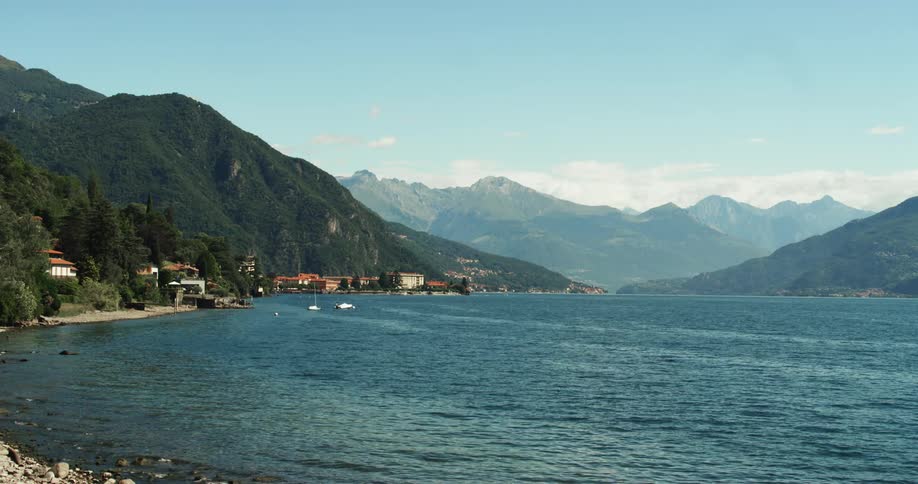 Calm surface of a lake in the mountains next to the waterfront houses of a small coastal town