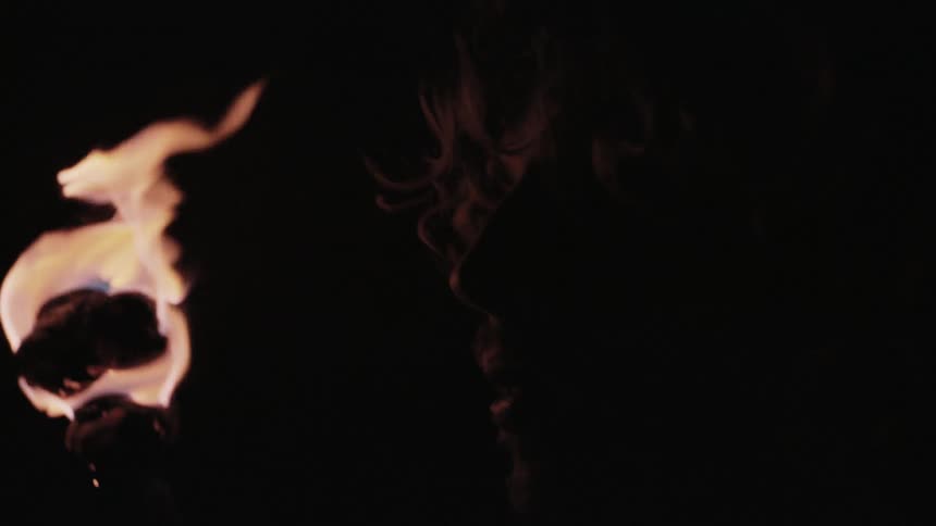 A man holding a torch while studying his surroundings