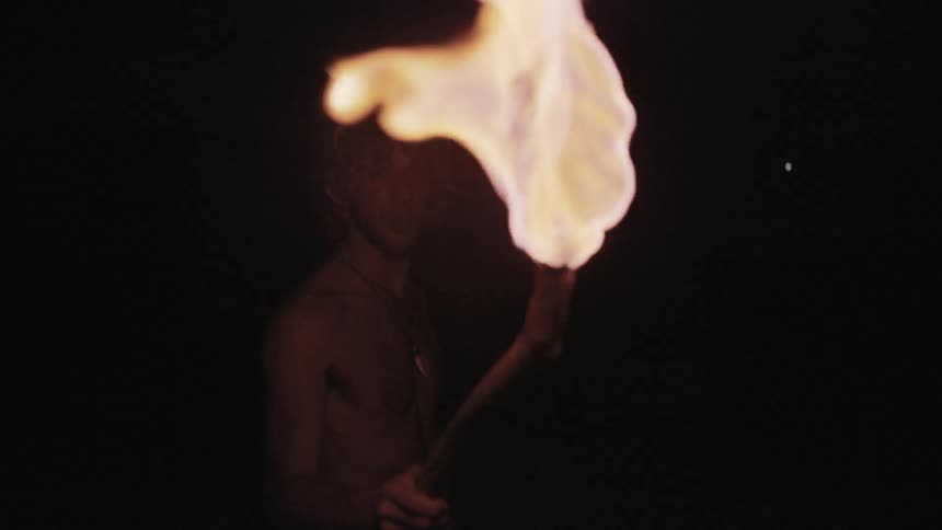 A man is holding a torch up in a dark area