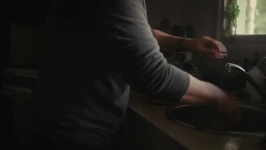 Woman runs water on lid to cool it then runs water on contents
