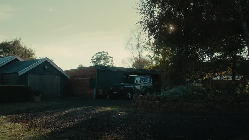 Black jeep parked near the backyard outside the garage of a house at morning