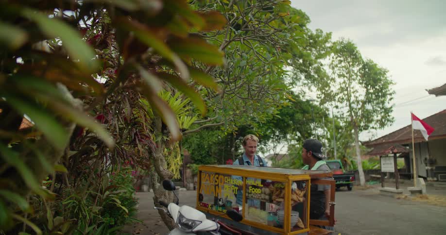 A man approaches a halal food cart and shakes the vendors hand
