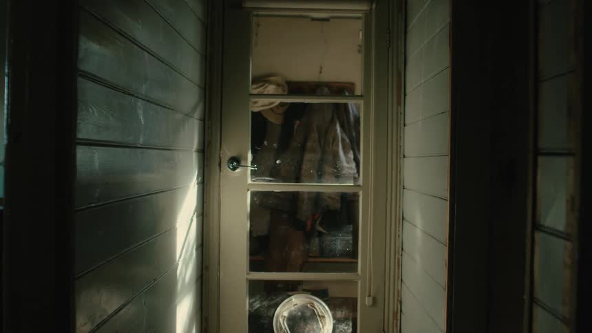 A door with glass windows and coats handing on a rack inside
