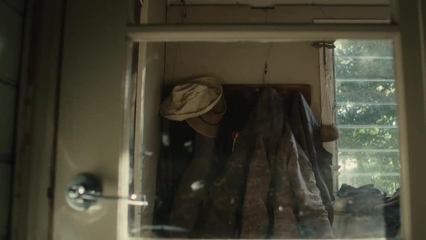 Coats and hats hanging on a wall mounted coat rack in a house