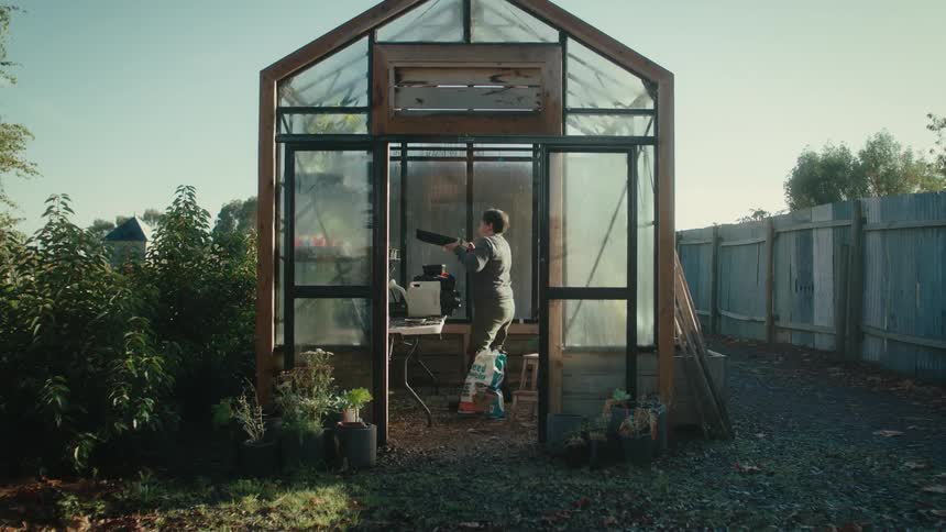A woman working in a rural greenhouse