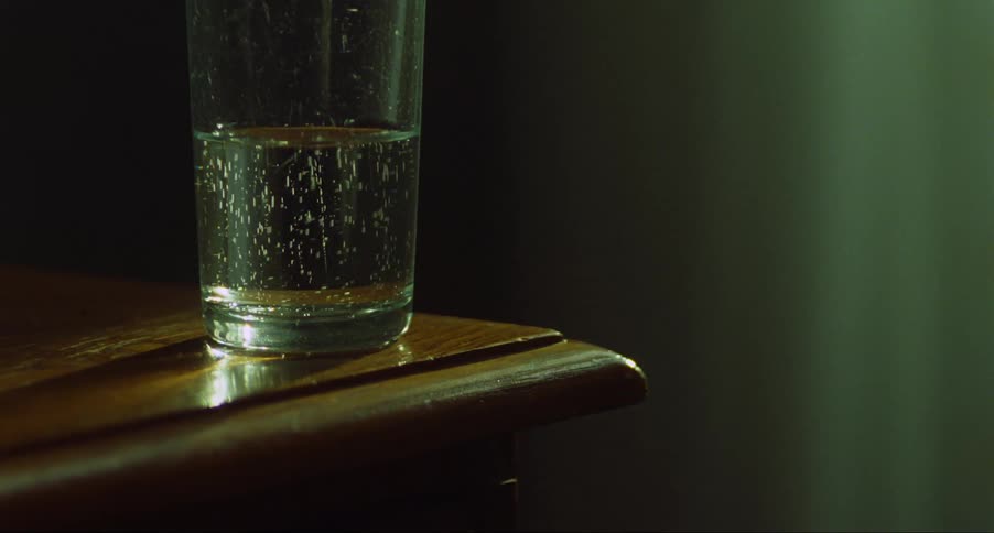 A glass of carbonated water sitting on a wood table