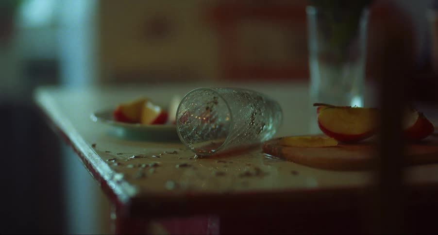 A spilled beverage dripping from the edge of a wood table