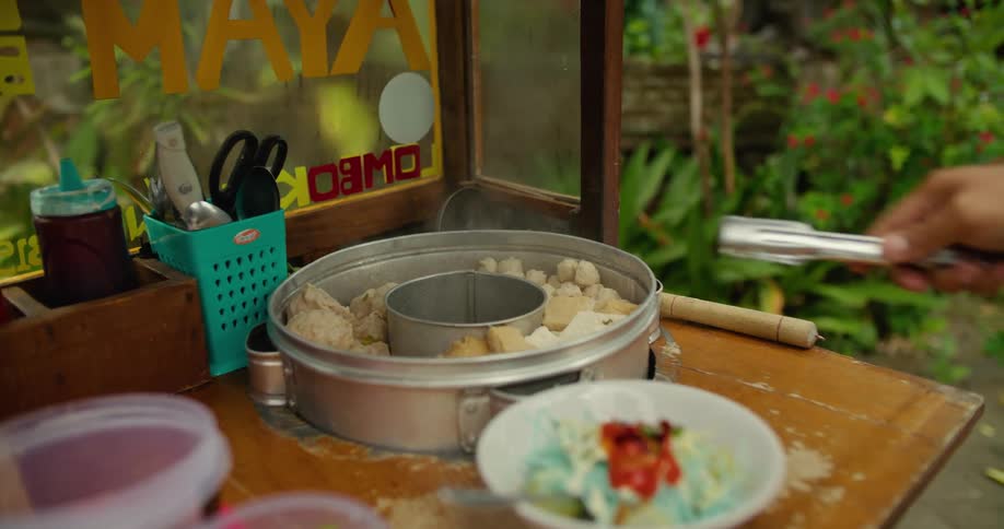 Street vendor prepares a dish of traditional halal food for a tourist