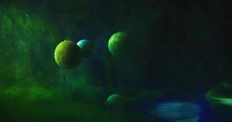 Green and blue spheres float in a dark space with green clouds