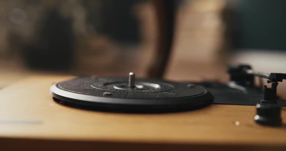 A person putting an album onto a record player