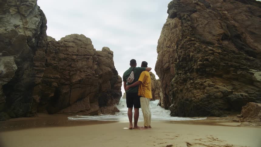 Two men kiss on the beach