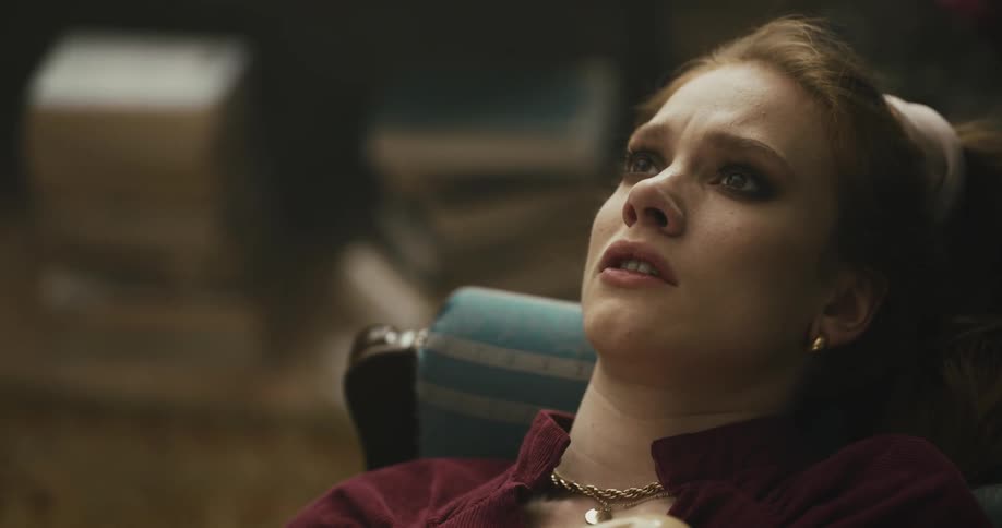 Elegant woman reclined on a couch in the living room receives bad news on the phone