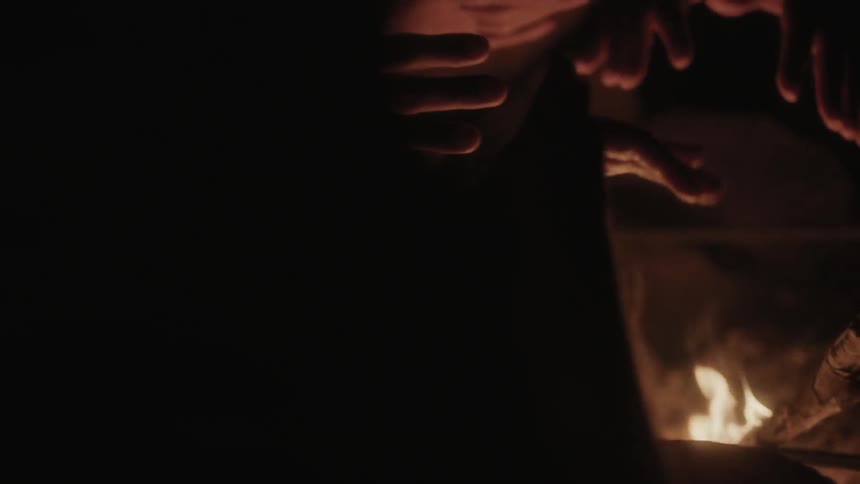 People are warming their hands on a fire