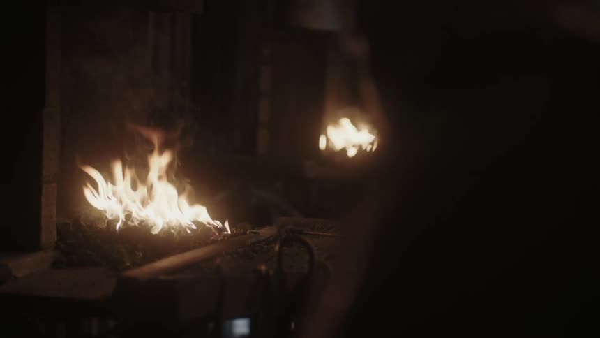 A man looks on at fires in a dark area