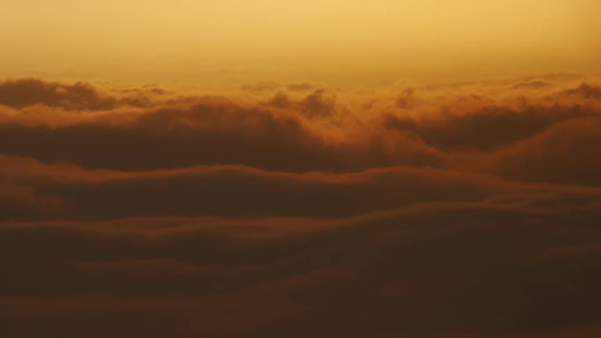 A view above red clouds moving as they are illuminated by the sun