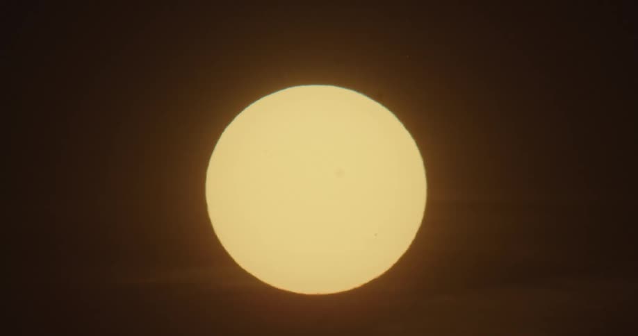 The sun appears large in the sky as it sets