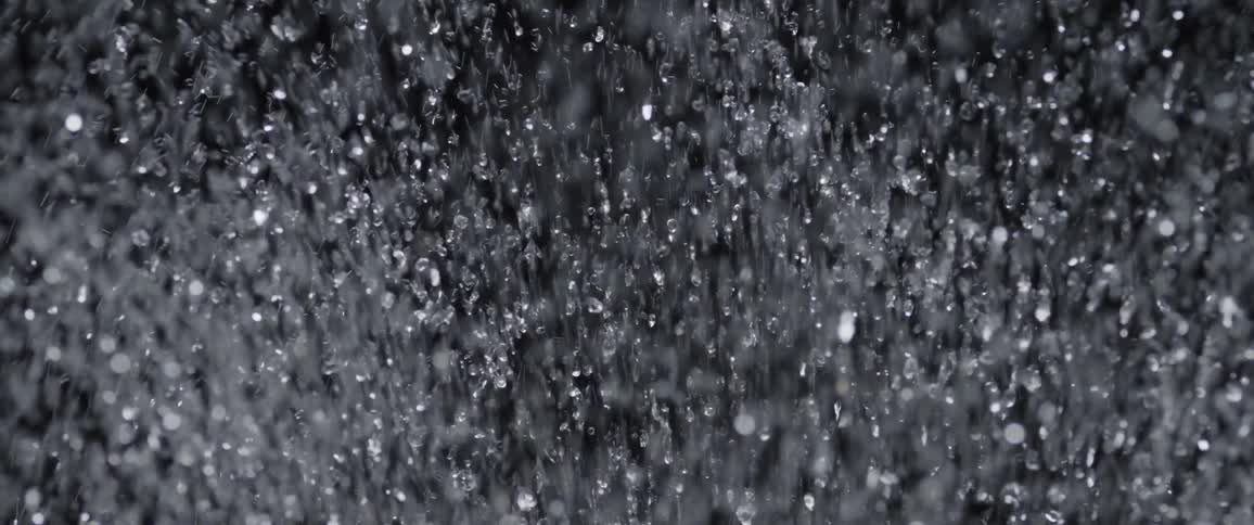 Water sprays up on dark background