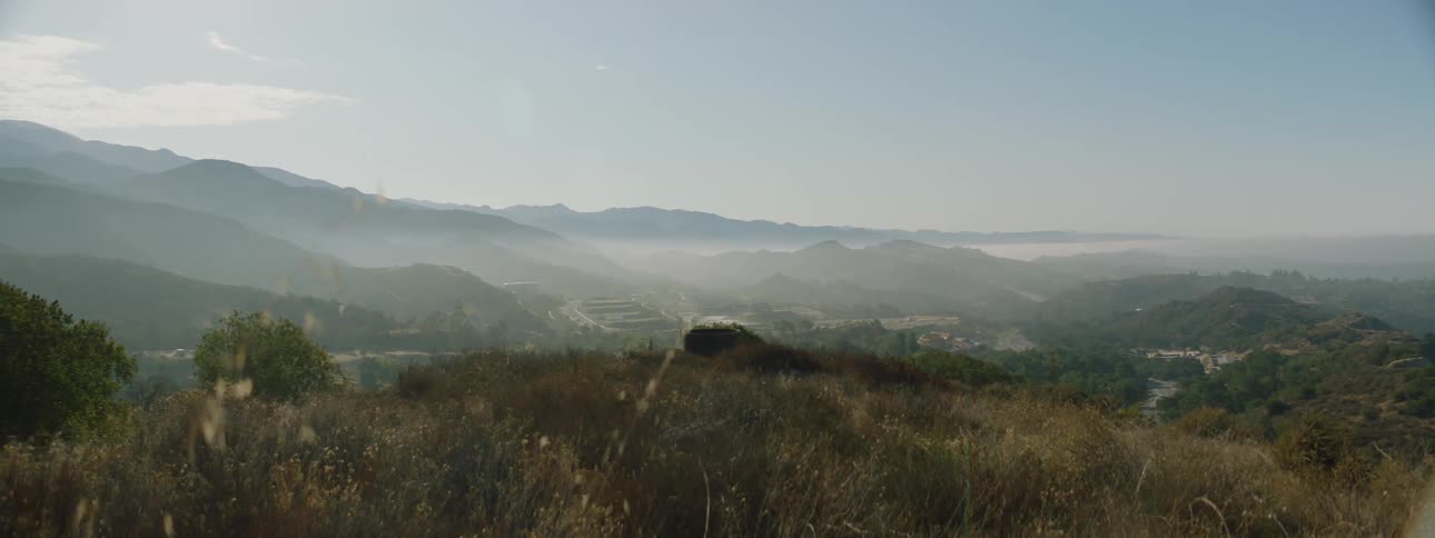Mist covering a small town on a valley next to the mountain at morning