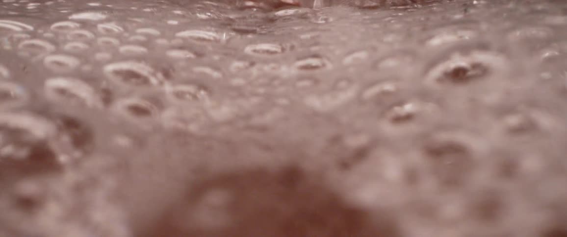 Water flowing into sink covers dishes in bubbles