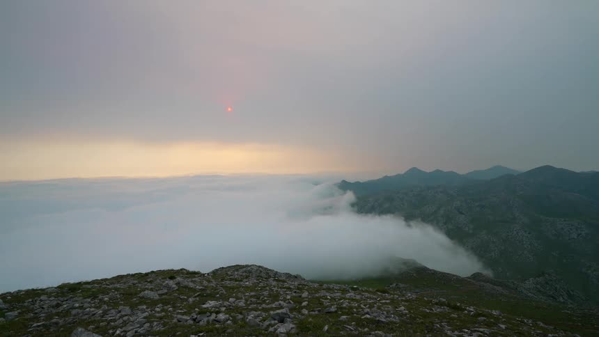 The clouds overflow a mountain top in the remote mountains of Asturias, Spain