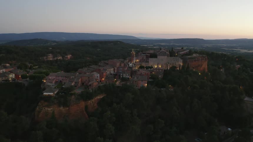 Aerial view of a small european town on top of a small mountain at evening