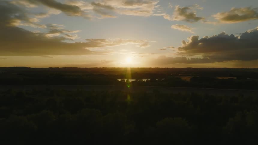 The sun setting over a river in a flat area