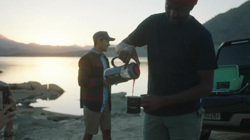 People have coffee together by the lake
