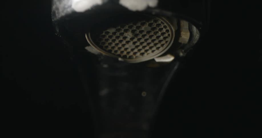 Water flows from a faucet then drips one drop at a time