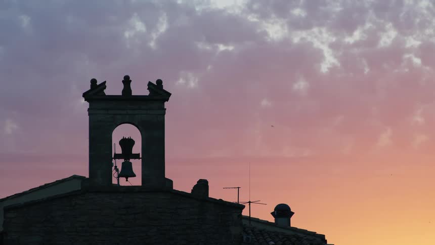 The sun is setting on the church