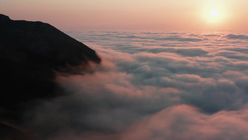 Dense clouds surround the peaks of a mountain range