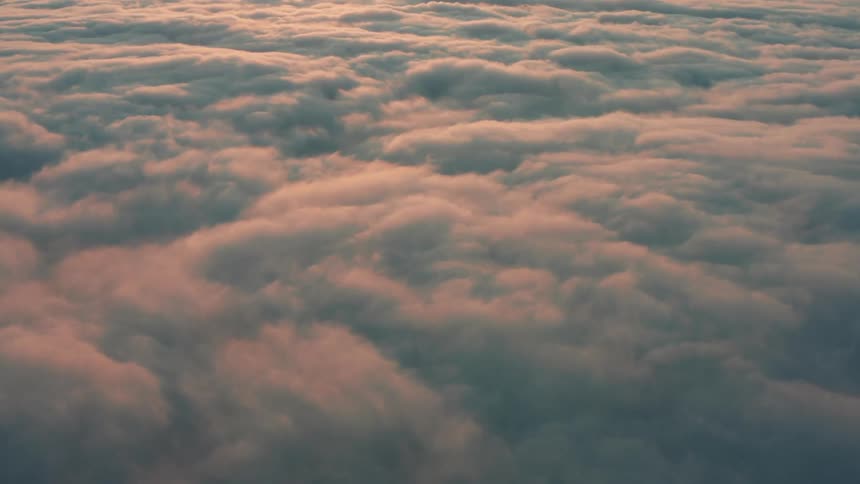 Thick layer of clouds is bathed in red sunlight at dawn