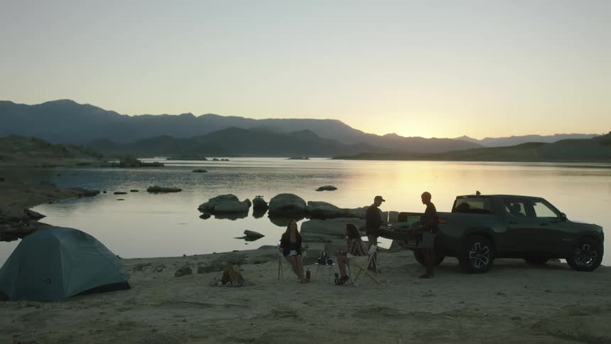 Campers talk and sit by the lake