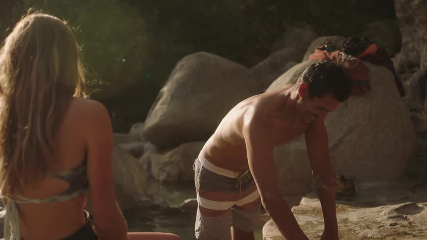 A man and woman smiling and laughing while swimming in a lake